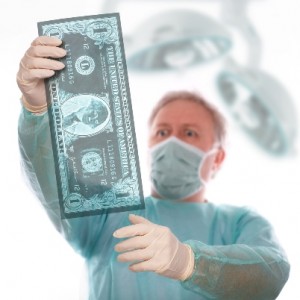 A surgeon holds up an x-ray of money